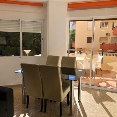 a dining room with a table and chairs and a balcony at Torres del Saler, Gola de Puchol, Valencia in Valencia