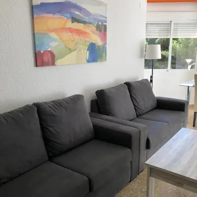 a living room with a couch and a painting on the wall at Torres del Saler, Gola de Puchol, Valencia in Valencia