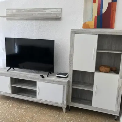 a gray entertainment center with a flat screen tv at Torres del Saler, Gola de Puchol, Valencia in Valencia