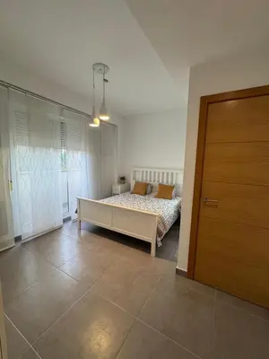 a bedroom with a bed and a wooden door at UIM Mediterraneo Hispanidad 4 Wifi in Puerto de Sagunto