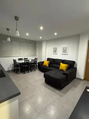 a living room with a black couch and a table at UIM Mediterraneo Hispanidad 4 Wifi in Puerto de Sagunto