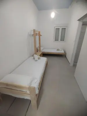 a white room with two beds and a table at Confortable apartamento cerca de la playa in Valencia