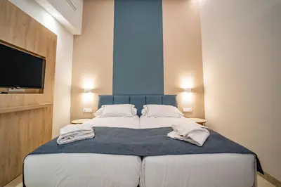 a hotel room with two beds and two pairs of shoes at Hotel San Lorenzo Boutique Catedral in Valencia