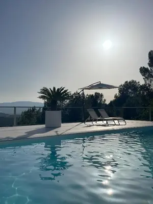 a swimming pool with two chairs and an umbrella at Casa with View in Alginet