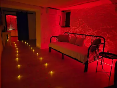 a red room with a couch and a red wall with lights at Bonita casa cueva con jacuzzi in Paterna