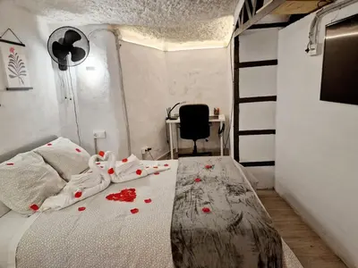 a bedroom with a bed with red flowers on it at Bonita casa cueva con jacuzzi in Paterna