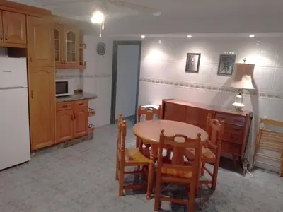 a kitchen with a table and chairs and a refrigerator at Pasaje Alzira 4B, 1-3 in Cullera
