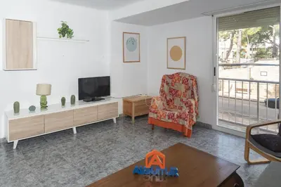 a living room with a tv and a chair at Pasaje Alzira 4B, 1-3 in Cullera