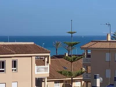 a view of the ocean from the roofs of buildings at Encantador Apartamento dúplex con vistas al mar in Canet de Berenguer