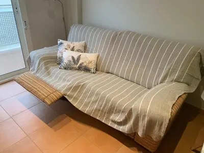 a couch with two pillows on it in a room at Encantador Apartamento dúplex con vistas al mar in Canet de Berenguer