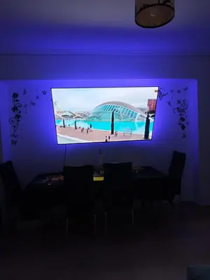 a tv screen in a room with a blue wall at Habitación Manises Aeropuerto in Manises