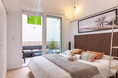 a bedroom with a large bed and a large window at SingularStays Olimpia in Valencia