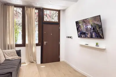 a living room with a couch and a tv on a wall at SingularStays Olimpia in Valencia