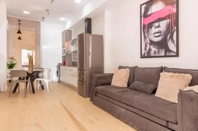 a living room with a couch and a kitchen at SingularStays Olimpia in Valencia