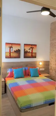 a bedroom with a colorful bed with two pictures on the wall at Flats Piera Valencia Center in Valencia