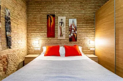 a bedroom with a large bed with red pillows at Flats Piera Valencia Center in Valencia