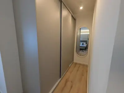 a hallway with a round mirror and a white wall at Port Suites Corporate Living Apartments in Valencia