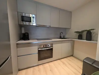 a kitchen with a stove and a microwave at Port Suites Corporate Living Apartments in Valencia