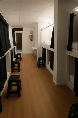 a room with several bunk beds and stools at Cozy Nook in Valencia
