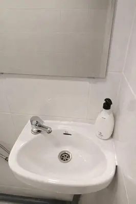 a white bathroom sink with a soap bottle on it at Cozy Nook in Valencia