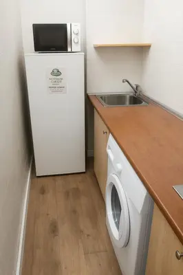 a kitchen with a white refrigerator and a sink at Cozy Nook in Valencia