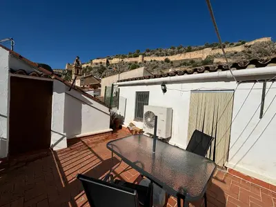 a patio with a table and chairs on a balcony at Casa Casidro in Chulilla