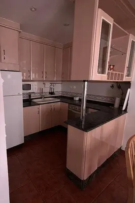 a kitchen with white cabinets and a black counter top at Casa Casidro in Chulilla