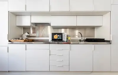 a kitchen with white cabinets and a counter top at Apartamento acogedor en el centro histórico de Sagunto in Sagunto