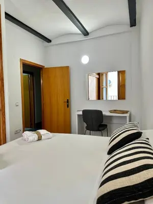 a bedroom with a white bed and a desk at Apartamento acogedor en el centro histórico de Sagunto in Sagunto