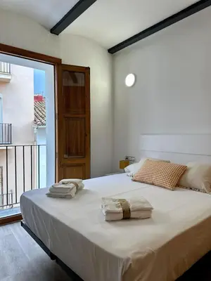 a kitchen with white cabinets and a couch and a table at Apartamento acogedor en el centro histórico de Sagunto in Sagunto