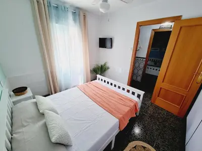 a small bedroom with a bed and a door at La Maison du Port in Puerto de Sagunto