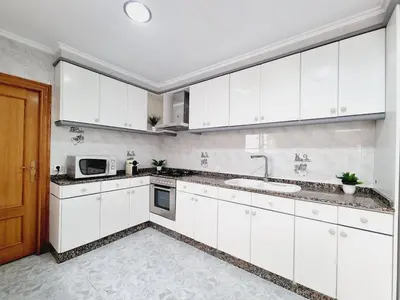 a white kitchen with a sink and a microwave at La Maison du Port in Puerto de Sagunto