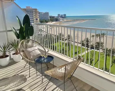 a balcony with chairs and a view of the ocean at Beach Apartment in Cullera