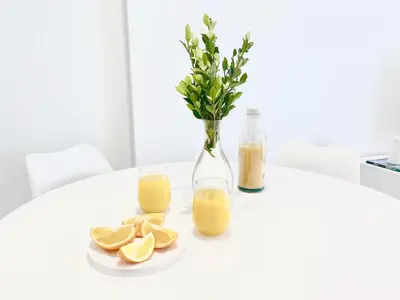 a white table with oranges and a vase with orange juice at Beach Apartment in Cullera