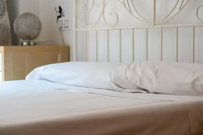a white bed with white sheets and pillows at Global Vacacional, Bonito apartamento cerca de la playa in Puerto de Sagunto
