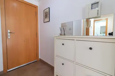 a kitchen with white cabinets and a wooden door at Global Vacacional, Bonito apartamento cerca de la playa in Puerto de Sagunto