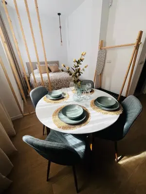 a dining room table with chairs and a white table with plates and glasses at Loft Sofia a estrenar con luz natural en corazon de Valencia in Valencia