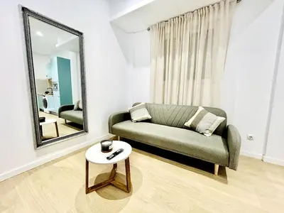 a living room with a couch and a mirror at Loft Sofia a estrenar con luz natural en corazon de Valencia in Valencia