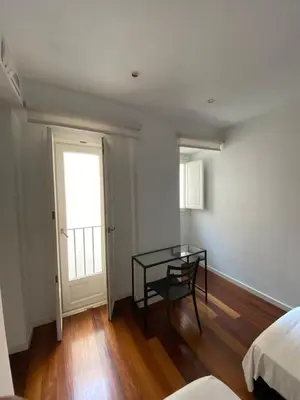 a bedroom with a table and a bed and a window at Apartamento dúplex en el corazón de Valencia in Valencia