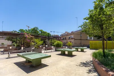a group of picnic tables and benches in a courtyard at VL - Carrer de Berni i Catala in Valencia
