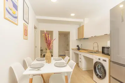 a kitchen and dining room with a white table and chairs at VL - Carrer de Berni i Catala in Valencia
