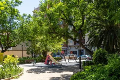 a playground with a slide in a park with trees at VL - Carrer de Berni i Catala in Valencia