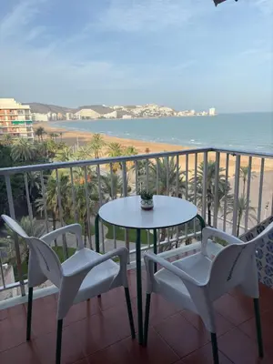 a balcony with a table and chairs and the ocean at Apartamento Oasis in Cullera