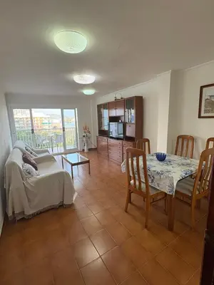 a living room with a table and a dining room at Apartamento Oasis in Cullera