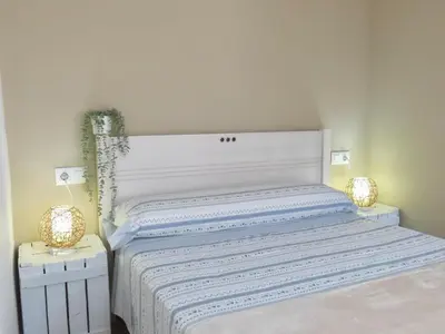 a bedroom with a white bed with two night stands at Casa Playamonte in Navarrés