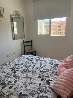 a bedroom with a bed and a mirror and a chair at Apartamento en Canet Berenguer Valencia in Canet de Berenguer