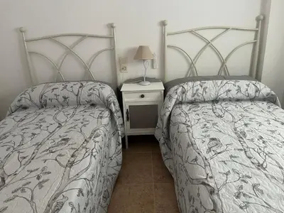 a bedroom with two beds and a table with a lamp at Apartamento en Canet Berenguer Valencia in Canet de Berenguer