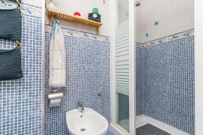 a blue tiled bathroom with a sink and a shower at Invalencia - Begis Flat Cabanyal in Valencia