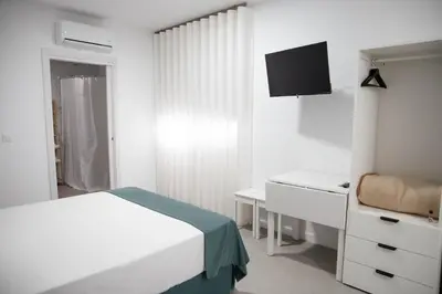 a bedroom with a bed and a desk and a tv at M&A Hostal en Onda in Bechí