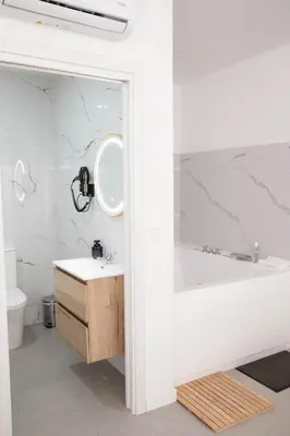 a bathroom with a tub and a sink and a mirror at M&A Hostal en Onda in Bechí